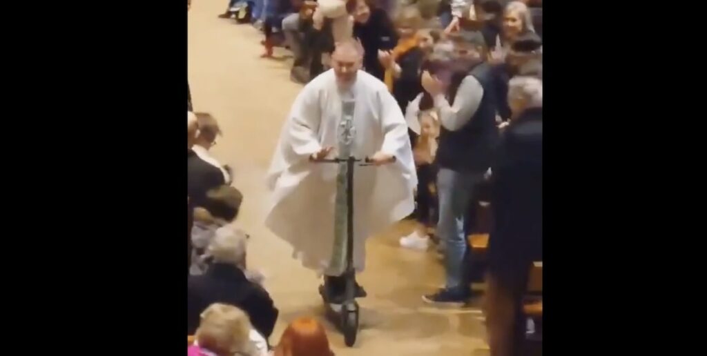 Il prete lascia la messa in monopattino con i fedeli in tripudio