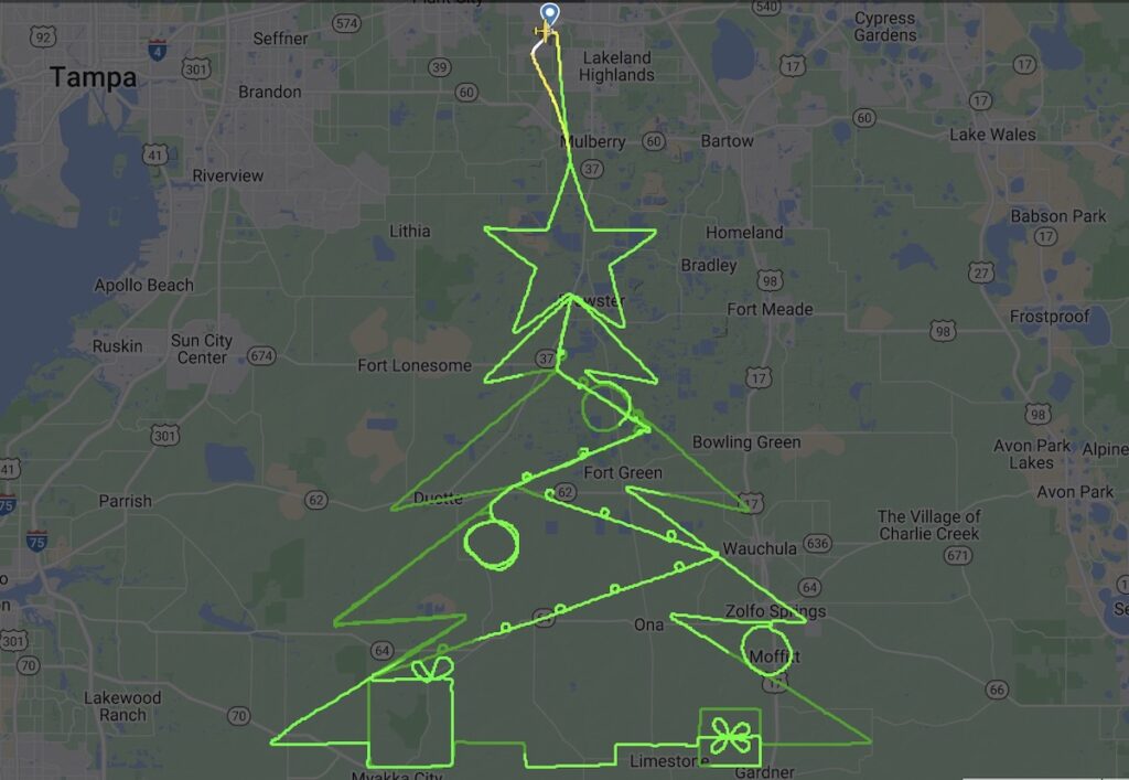 Un aereo disegna in volo un albero di Natale con tanto di regali