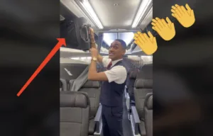 Assistente di volo sistema un bagaglio a mano nella cappelliera dell’aereo con una freccia rossa e emoji di applausi