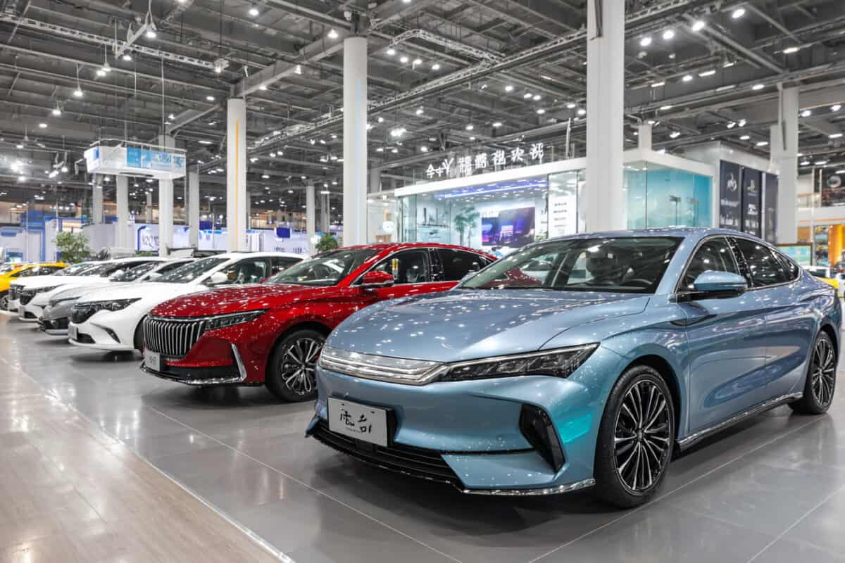 Auto elettriche in esposizione in showroom, colori vari, vista laterale, ambiente illuminato, vetrina di modelli.