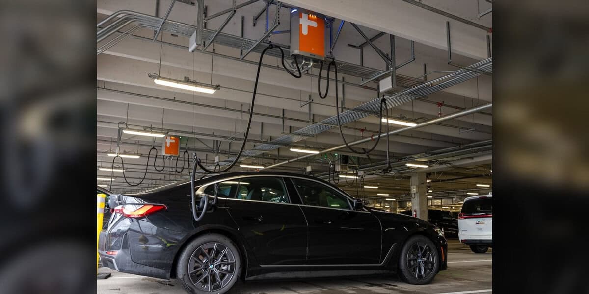 Colonnine di ricarica sospese in un parcheggio a Portland, con auto elettriche in carica
