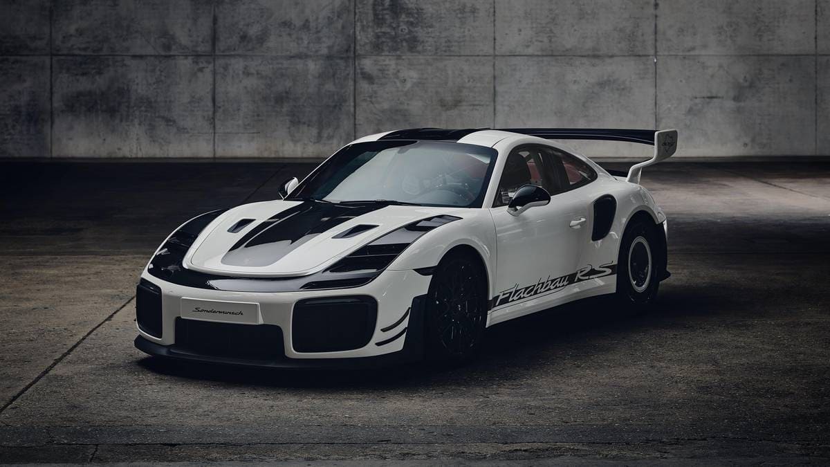 Porsche 911 GT2 RS Flachbau RS con carrozzeria bianca, stripe nere, ala posteriore e cerchi scuri.
